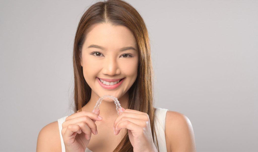 Woman Holding Clear Aligners