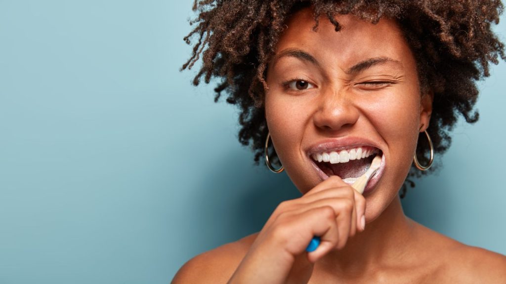Woman Brushing Teeth With Playful Expression