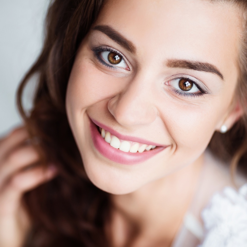 Portrait of smiling woman with perfect smile and white teeth looking at camera.