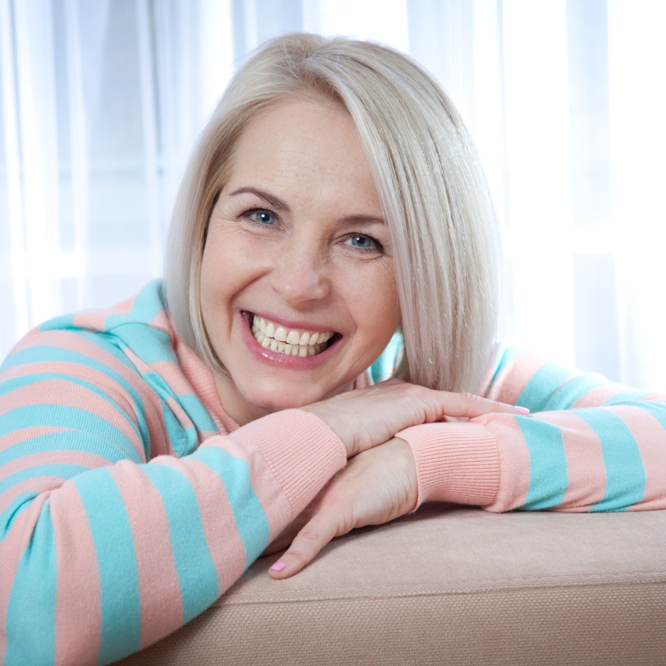 Attractive middle aged woman relaxing at home. The beautiful face close up.