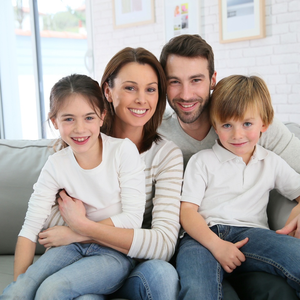 Cheerful family at home sitting in sofa