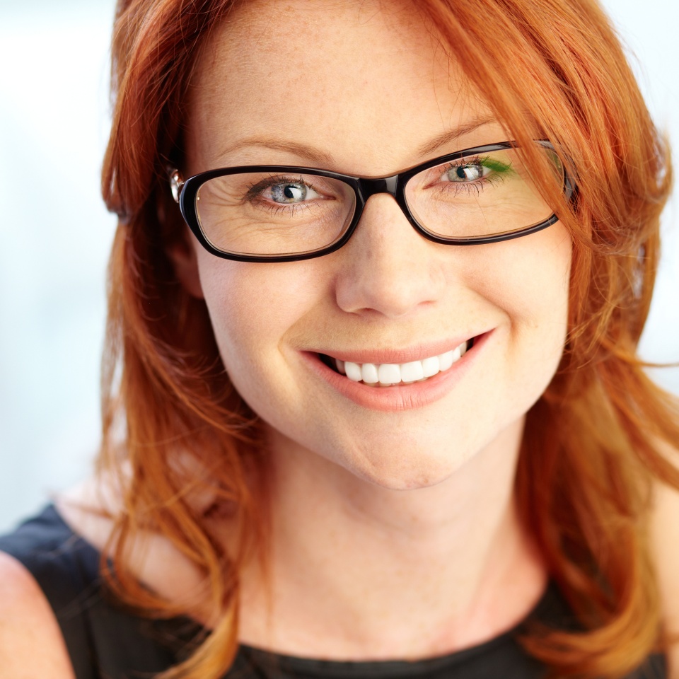 Close-up shot of a wonderful red-haired woman looking at camera