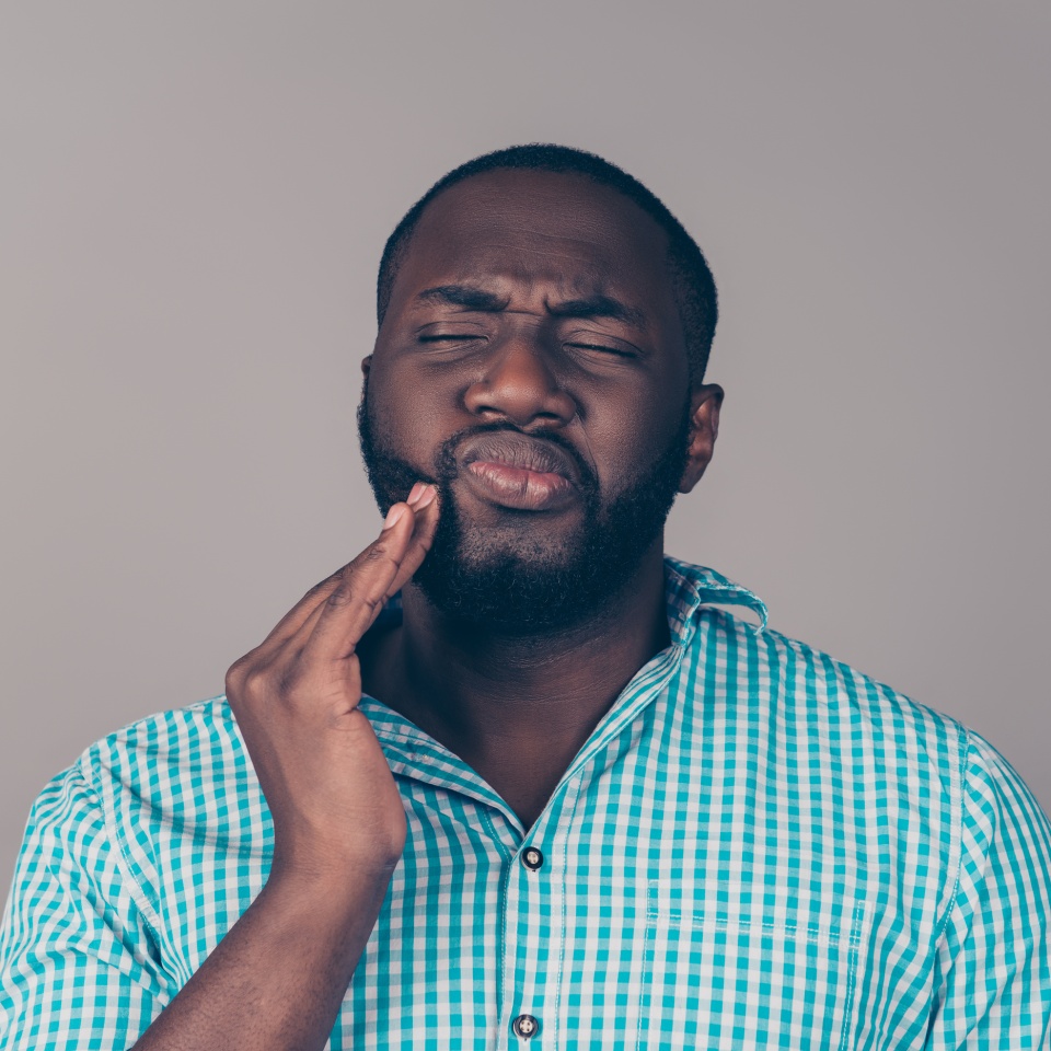 Portrait of bearded afroamerican man touch cheek. He have strong tooth ache