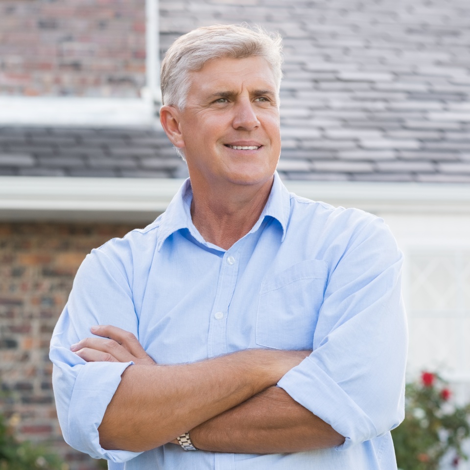 Successful happy retired man standing with crossed arm. Senior man thinking and looking away. Portrait of old man feeling good to retire.