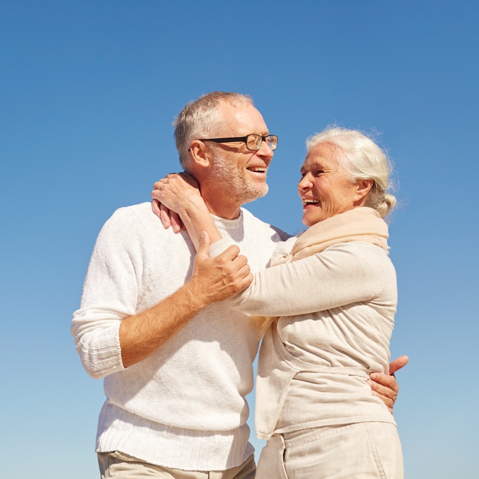 happy senior couple hugging outdoors