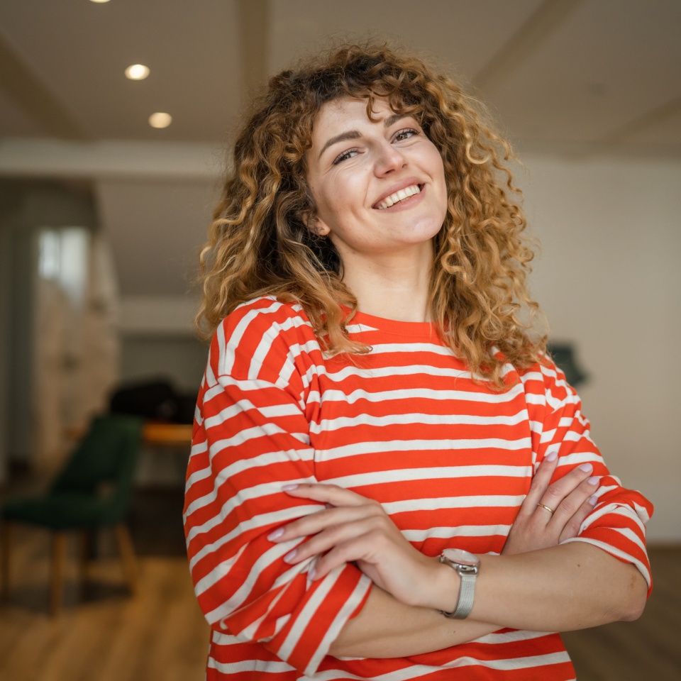 One woman caucasian female happy confident stand indoor at cafe with curly hair portrait smile real person copy space