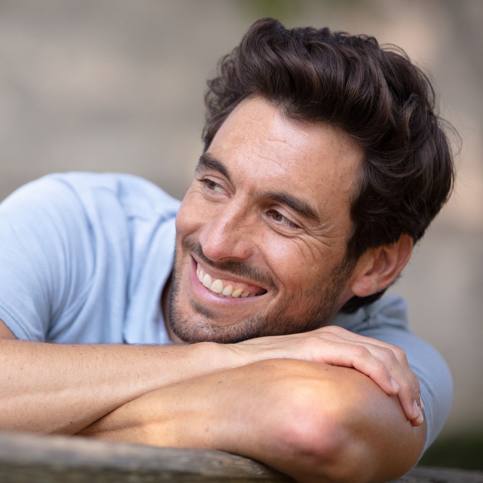 young man relaxing on park bench on a summers day