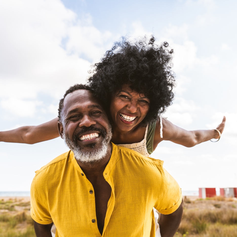 Beautiful mature black couple of lovers dating at the seaside - Married african middle-aged couple bonding and having fun outdoors, concepts about relationship, lifestyle and quality of life
