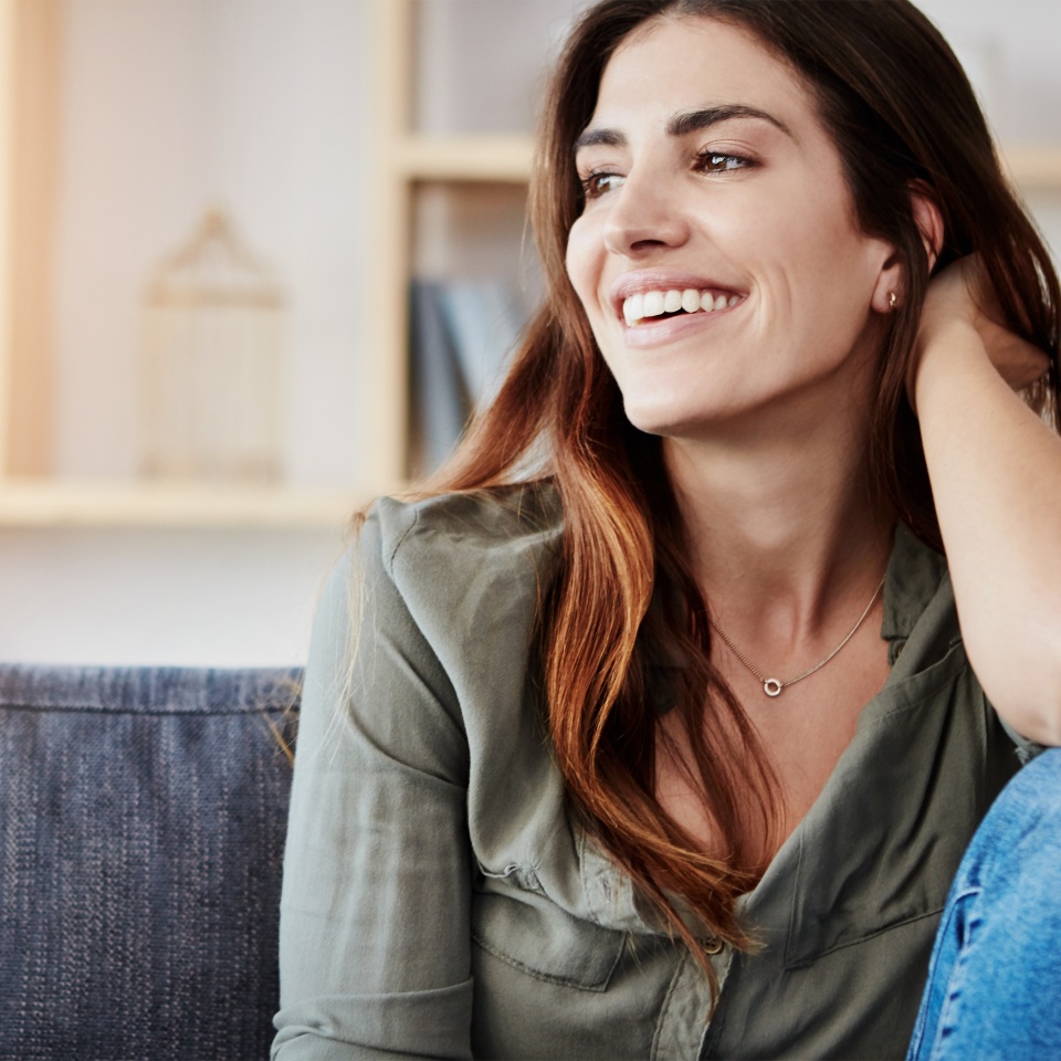 Relax, couch and woman in home for thinking, smile and living room for alone and break on weekend. Happy, calm and ideas in apartment for female person, lounge and comfort on sofa in Los Angeles