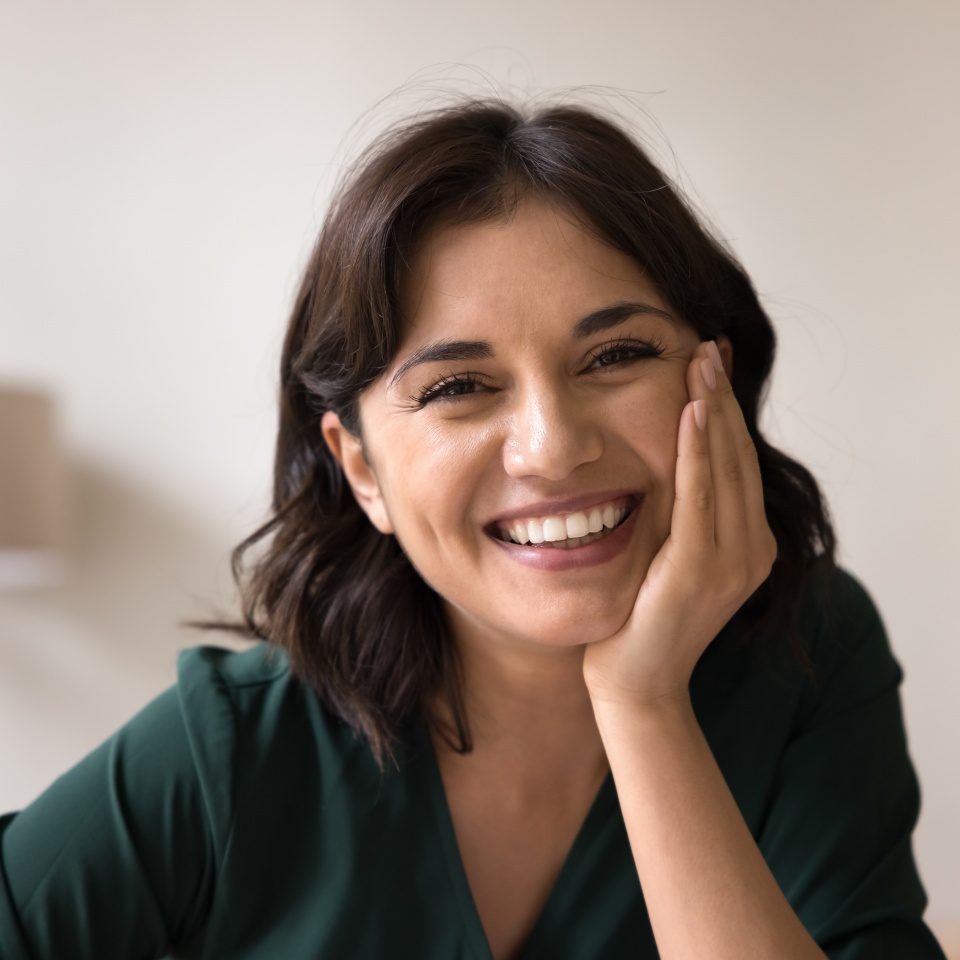 Beauty and wellness. Head shot portrait beautiful young adult woman with light natural makeup on face sit indoors in comfortable pose look at camera with white smile enjoy healthy lifestyle self care