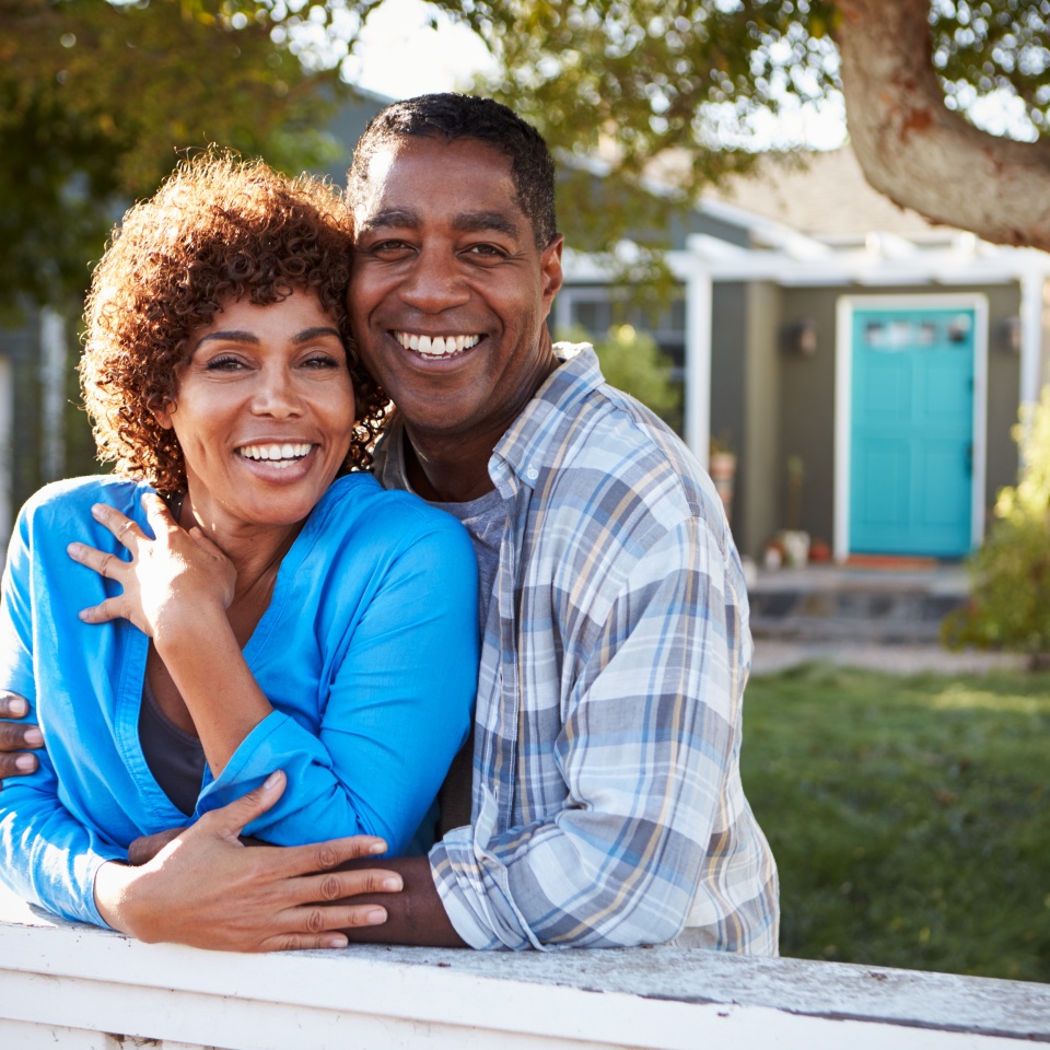 Portrait Of Mature Couple Looking Over Back Yard Fence