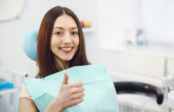 Beautiful patient sits in a chair at the dentist